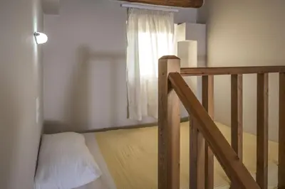 a room with a staircase with a bed and a window at Athina Luxury Villas in Xamoudhokhórion