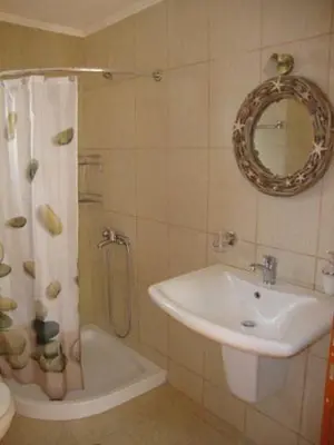 a bathroom with a sink and a shower with a mirror at Ravdoucha Beach Studios in Ravdhoúkha