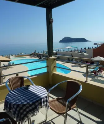 a table and chairs next to a swimming pool at Lissos Beach in Plataniás