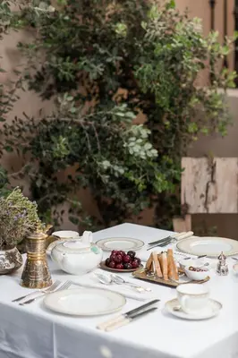 a table with white plates and fruit on it at La Maison Ottomane in Chania Town