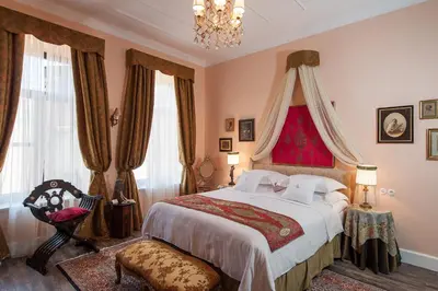 a bedroom with a large bed and a chandelier at La Maison Ottomane in Chania Town