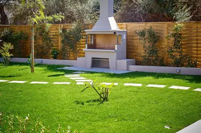 a backyard with a lawn with a barbecue in it at Villa Calliope in Chania Town