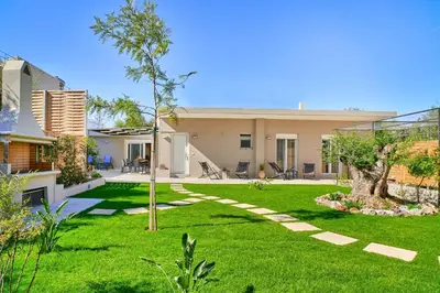 a yard with green grass and a house at Villa Calliope in Chania Town
