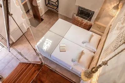 an overhead view of a bed in a room with a fireplace at Verekinthos Villas - Pool, Hot Tub, BBQ, Kids Playground, Stunning Mountain Views in Gerolakkos