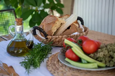 a basket of bread next to a plate of vegetables at Verekinthos Villas - Pool, Hot Tub, BBQ, Kids Playground, Stunning Mountain Views in Gerolakkos