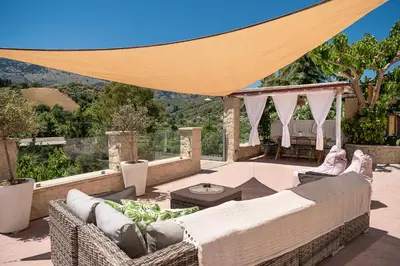 a patio with couches and a table with a view at Verekinthos Villas - Pool, Hot Tub, BBQ, Kids Playground, Stunning Mountain Views in Gerolakkos