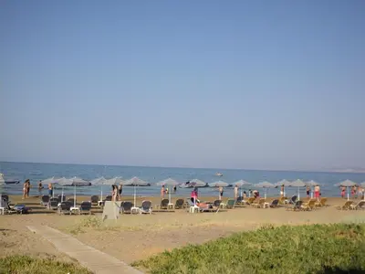 a group of people on a beach with umbrellas at Thodorou Village in Agia Marina Nea Kydonias