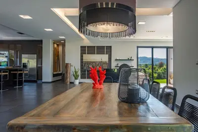 a dining room with a wooden table and a kitchen at Villa Vega I 