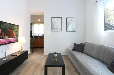 a living room with a couch and a tv at Comfy Apartment in Chania Town
