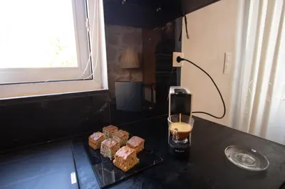 a table with a glass of coffee and some food at Comfy Apartment in Chania Town
