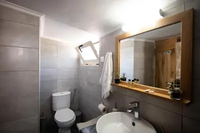 a bathroom with a toilet and a sink and a mirror at Comfy Apartment in Chania Town