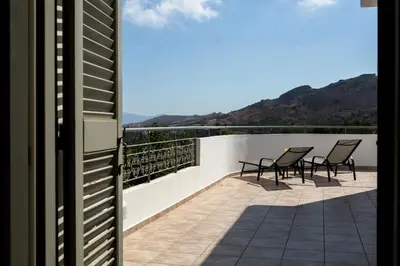 a balcony with chairs and a view of the mountains at Basilikos traditional house, 10' from Falasarna in Kissamos