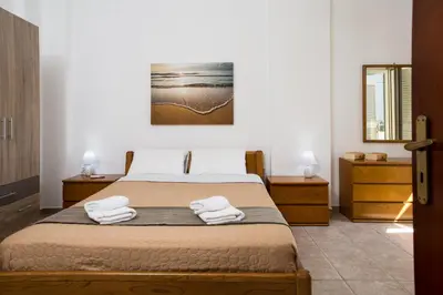 a bedroom with a bed with two towels on it at Basilikos traditional house, 10' from Falasarna in Kissamos