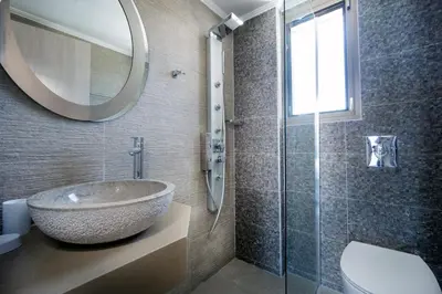 a bathroom with a sink and a glass shower at Beach Villas in Chania Town