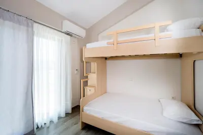 a bedroom with two bunk beds and a window at Beach Villas in Chania Town