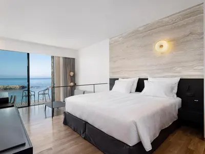 a bedroom with a bed and a view of the ocean at The Tanneries Hotel & Spa - a Member of Design Hotels in Chania Town