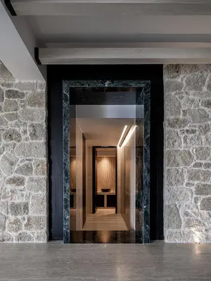 a hallway with a stone wall and a mirror at The Tanneries Hotel & Spa - a Member of Design Hotels in Chania Town