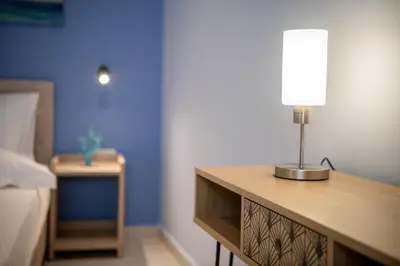a table with a lamp on top of it in a bedroom at M City Apartments 100m from the beach in Chania Town