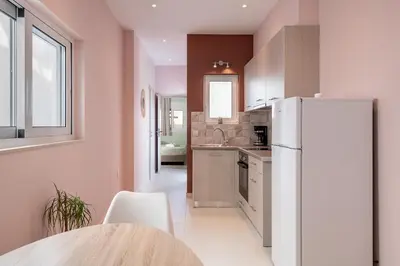 a kitchen with a white refrigerator and a table at M City Apartments 100m from the beach in Chania Town