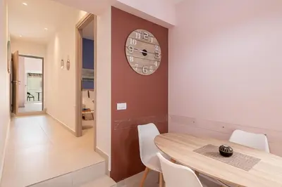 a dining room with a table and a clock on a wall at M City Apartments 100m from the beach in Chania Town