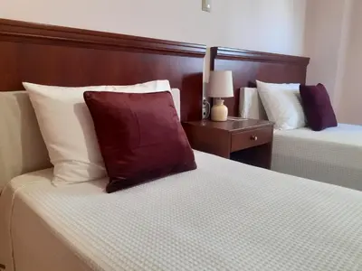 a bedroom with two beds and a red pillow on the bed at House escape in Chania Town