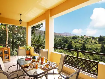a table and chairs on a balcony with a view at Holiday home with pool in Kalamítsion Alexándrou