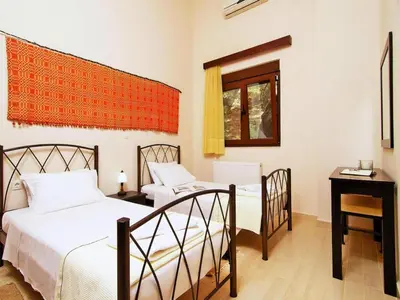 a bedroom with two beds and a table and a window at Holiday home with pool in Kalamítsion Alexándrou