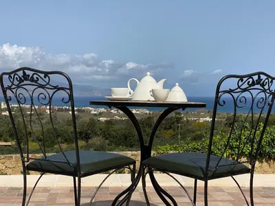 two chairs and a table with tea sets on it at ARIALKiS - ΑΡΙΑΛΚίΣ in Plataniás