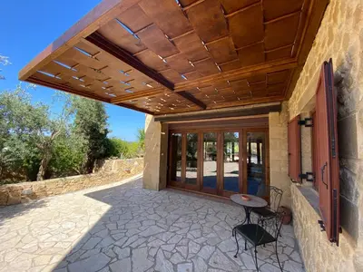 an outdoor patio with a wooden pergola at ARIALKiS - ΑΡΙΑΛΚίΣ in Plataniás