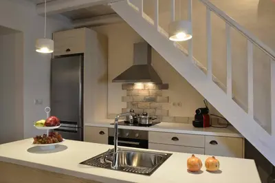 a kitchen with a sink and a stove and a staircase at Villa Christini a luxury villa with amazing views in Tzitzifés