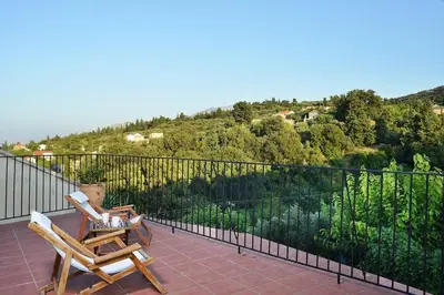 two chairs sitting on the balcony of a house at Villa Christini a luxury villa with amazing views in Tzitzifés