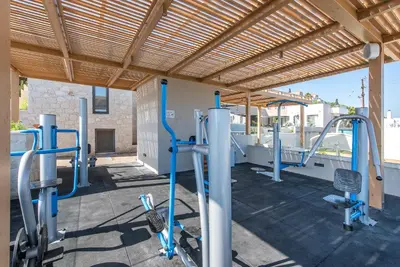 a gym with several tread machines and a wooden ceiling at Caldera Village in Agia Marina Nea Kydonias