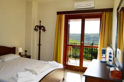a bedroom with a bed and a large window at Villa Spilia Homeleader in Spiliá