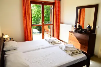 a bedroom with a bed and a dresser and a window at Villa Spilia Homeleader in Spiliá