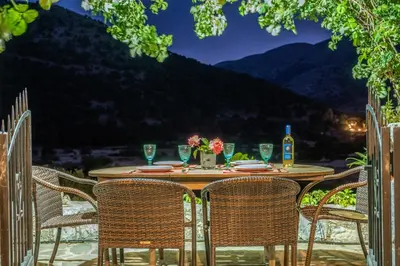 a table with chairs on a patio with a view at Private Stone villa-Pool and Maountain view in Karés