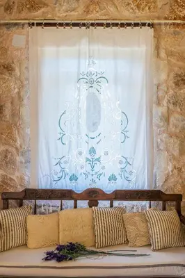 a couch in front of a window with a curtain at Private Stone villa-Pool and Maountain view in Karés