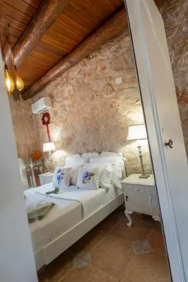 a bedroom with a bed and a stone wall at Private Stone villa-Pool and Maountain view in Karés
