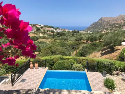 a villa with a swimming pool and flowers at Villa Ravdoucha Homeleader in Ravdhoúkha