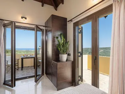 a bedroom with a sliding glass door with a plant at Villa Hibiscus in Spiliá