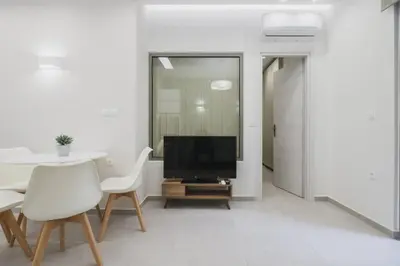 a living room with a tv and a table and chairs at Peris 1 - Central Apt near Old Town with Parking in Chania Town