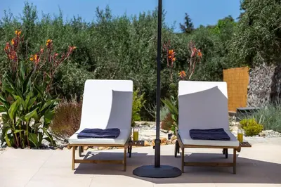 two white chairs sitting next to a pole at Canna Villa in Vamos