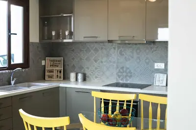 a kitchen with yellow chairs and a glass table at Mike's apartment I Luxury above the sea in Kissamos