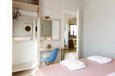 a bedroom with a pink bed and a blue chair at Mike's apartment I Luxury above the sea in Kissamos
