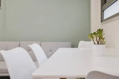 a white dining room with a white table and chairs at Peris 2 - Central Apt near Old Town - AC, Washer in Chania Town