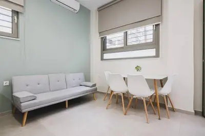a living room with a couch and a table and chairs at Peris 2 - Central Apt near Old Town - AC, Washer in Chania Town