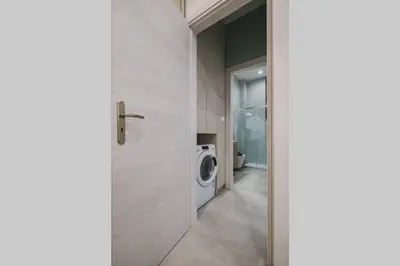 a laundry room with a washing machine and a door at Peris 2 - Central Apt near Old Town - AC, Washer in Chania Town