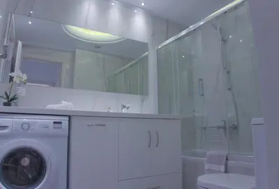 a bathroom with a washing machine and a shower at New Big Modern City Center Apartment in Chania Town