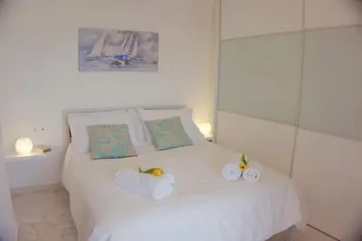 a bedroom with a white bed with towels on it at New Big Modern City Center Apartment in Chania Town