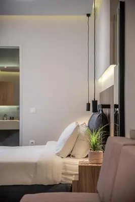 a bedroom with a bed and a table with a potted plant at Morum City Hotel Chania in Chania Town