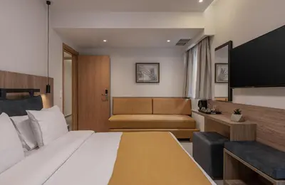 a hotel room with a bed and a couch at Morum City Hotel Chania in Chania Town